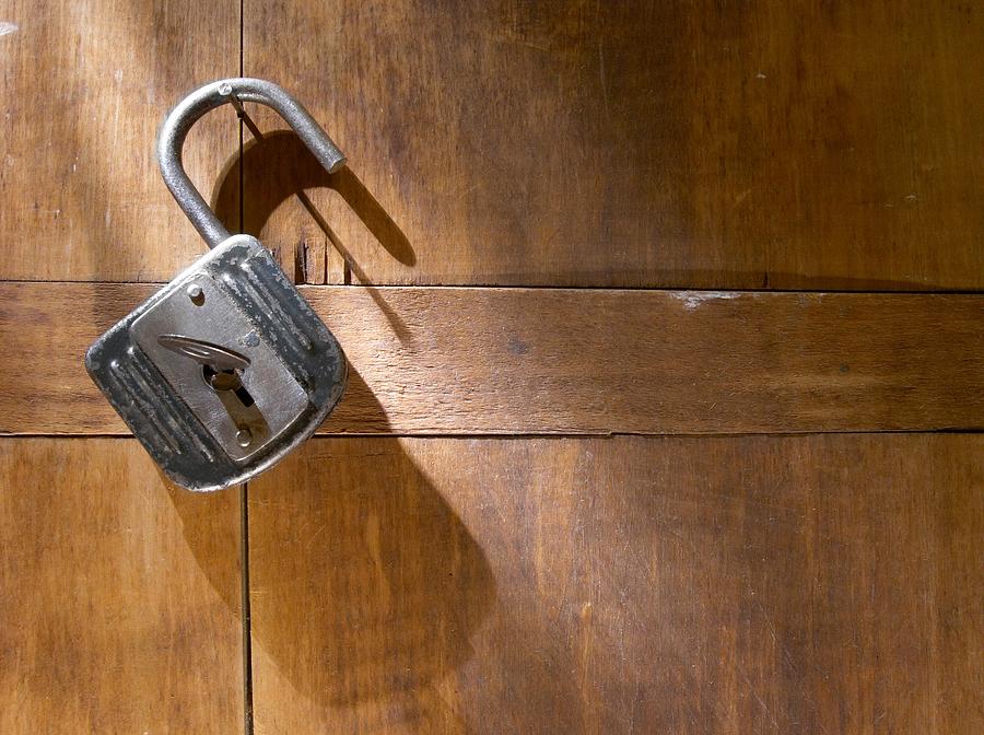 An antique padlock against a wood background Photograph by Shulz