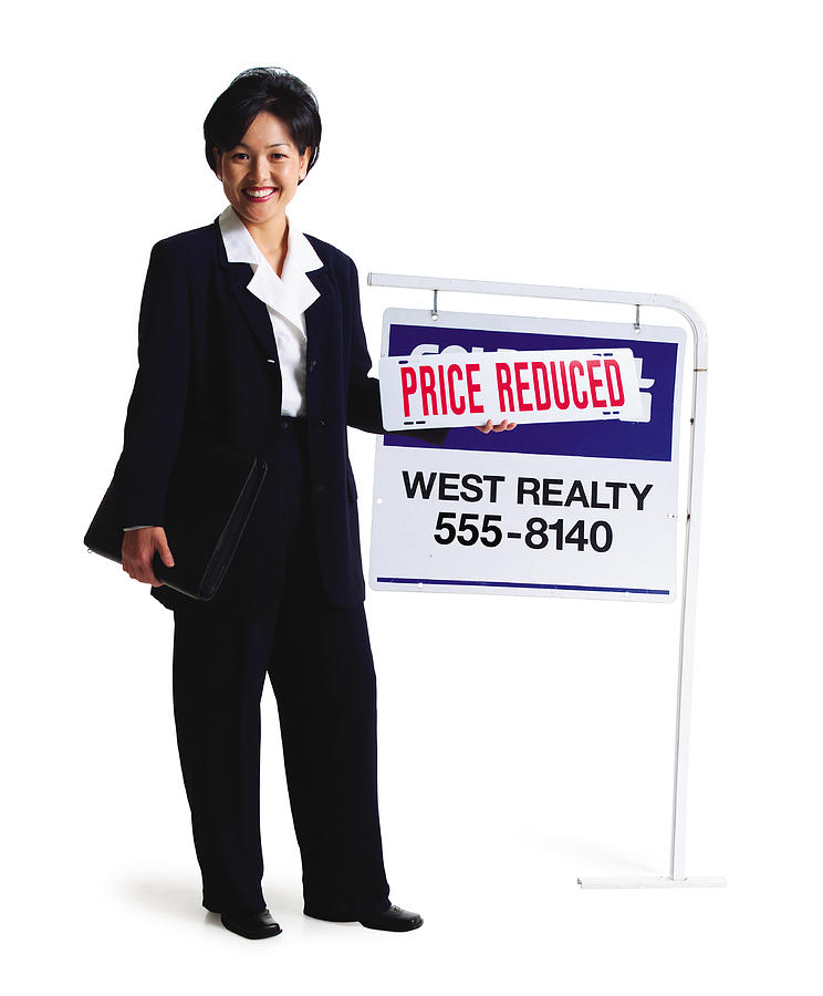 An Asian Female Realator Stands Smiling By A For Sale Sign Photograph by Photodisc