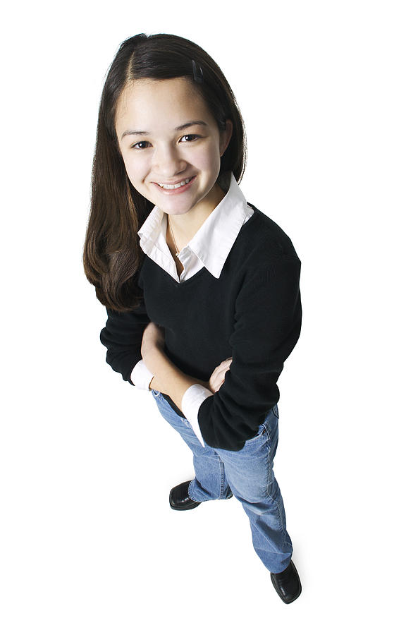 An Asian Female Teen In Jeans And A Black Sweater Folds Her Arms And Smiles Up At The Camera Photograph by Photodisc