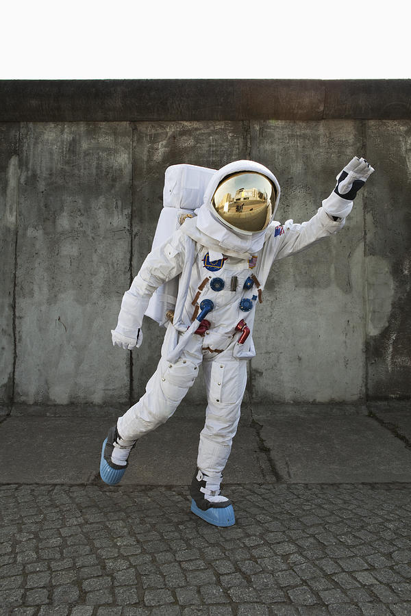 An astronaut on a city sidewalk pretending to take off in flight Photograph by Caspar Benson