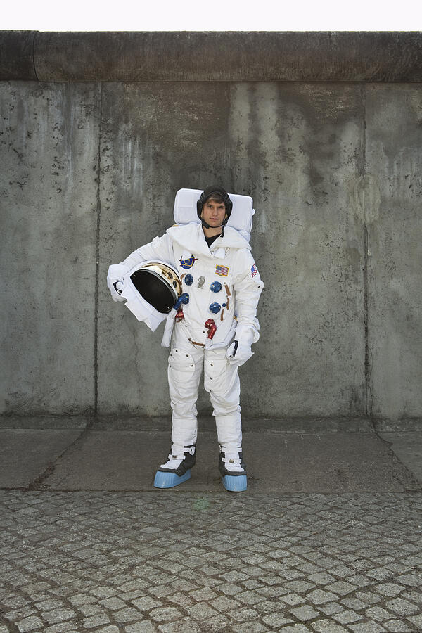 An astronaut standing on a sidewalk in a city Photograph by Caspar Benson