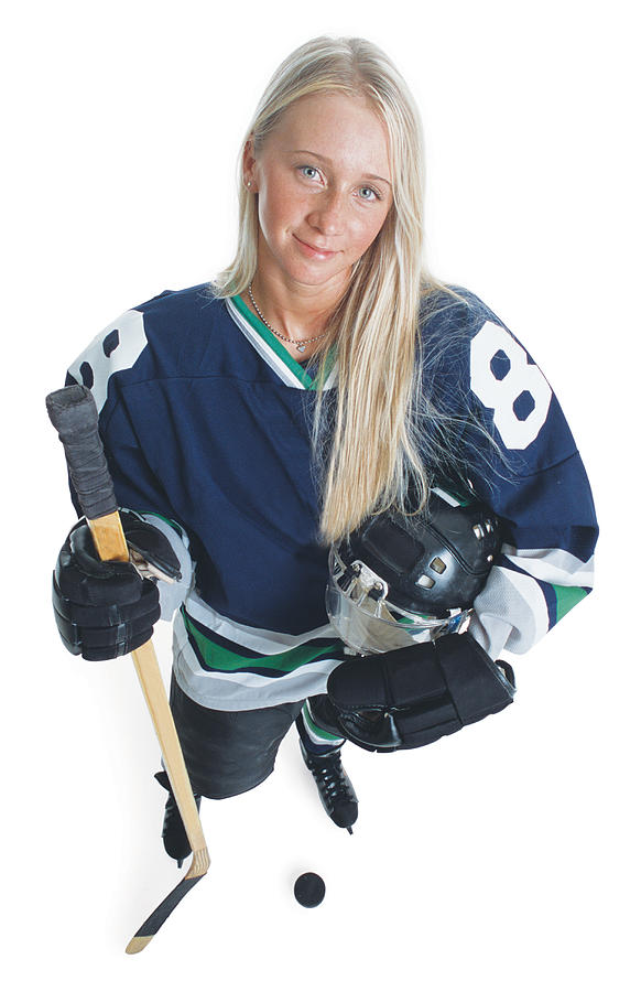 An attractive young caucasian female hockey player with long blonde hair and wearing a blue jersey smiles as she looks up at the camera Photograph by Photodisc
