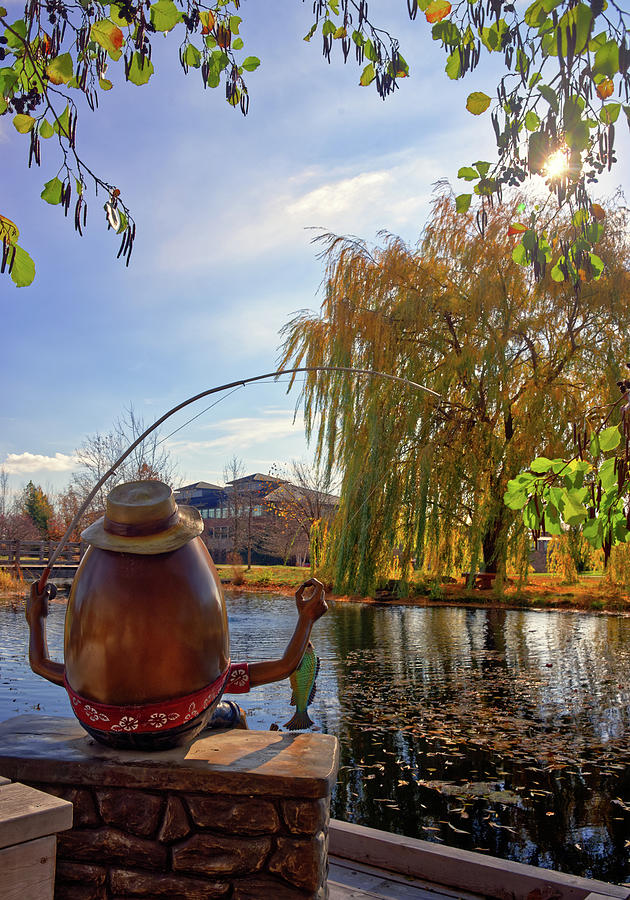 An Epic Fishing Hole -  Humpty Dumpty catches a fish at the Voyager Hall pond on Epic Systems campus Photograph by Peter Herman