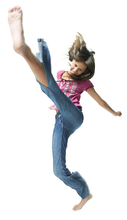An Ethnic Teenage Girl In Jeans And A Pink Shirt Jumps And Kicks Through The Air Photograph by Photodisc