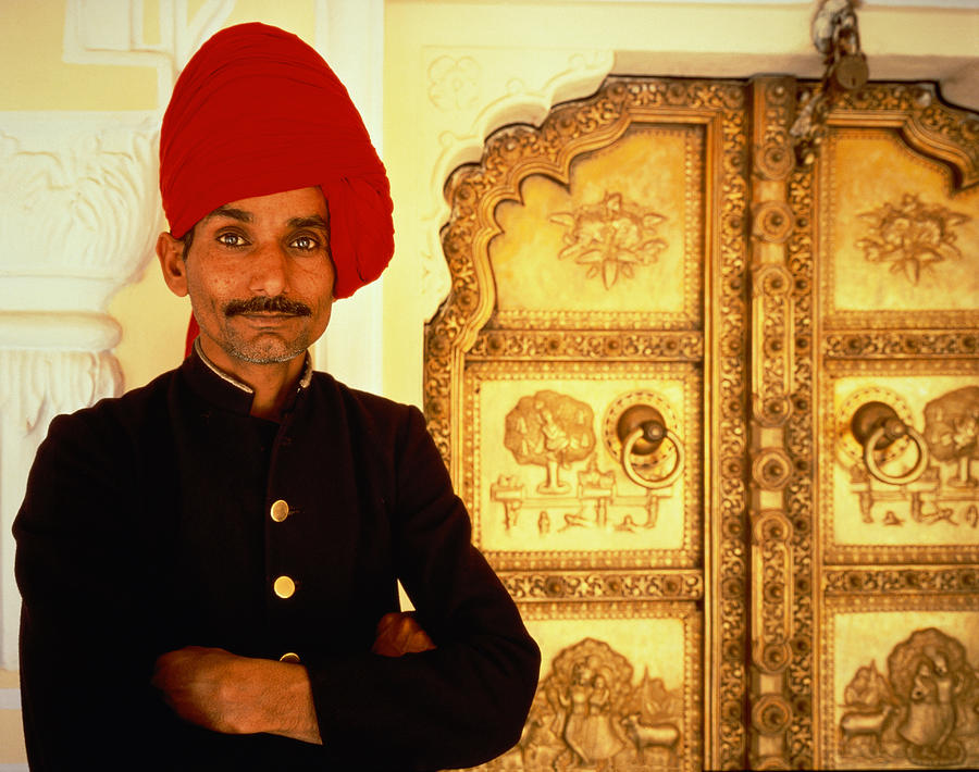 An Indian guardsman standing in front of a golden door, India, Jaipur, City Palace, half port Photograph by Hugh Sitton