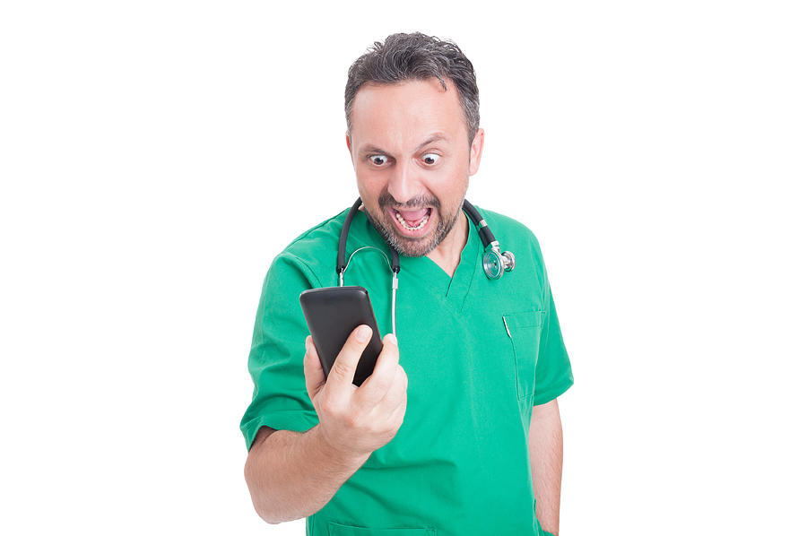 Angry doctor looking and yelling at his smartphone Photograph by Catalin205