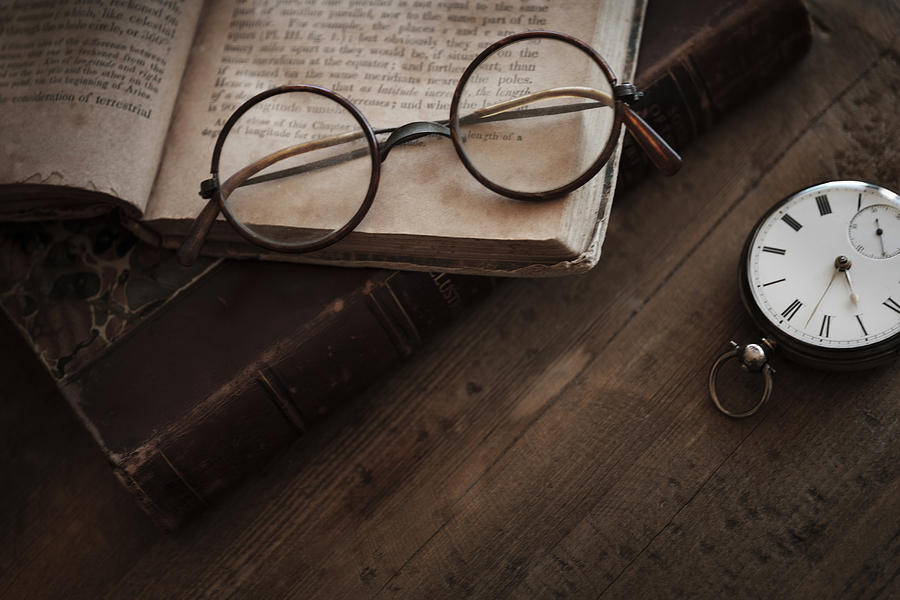 Antique book, watch and eyeglasses Photograph by Tetra Images