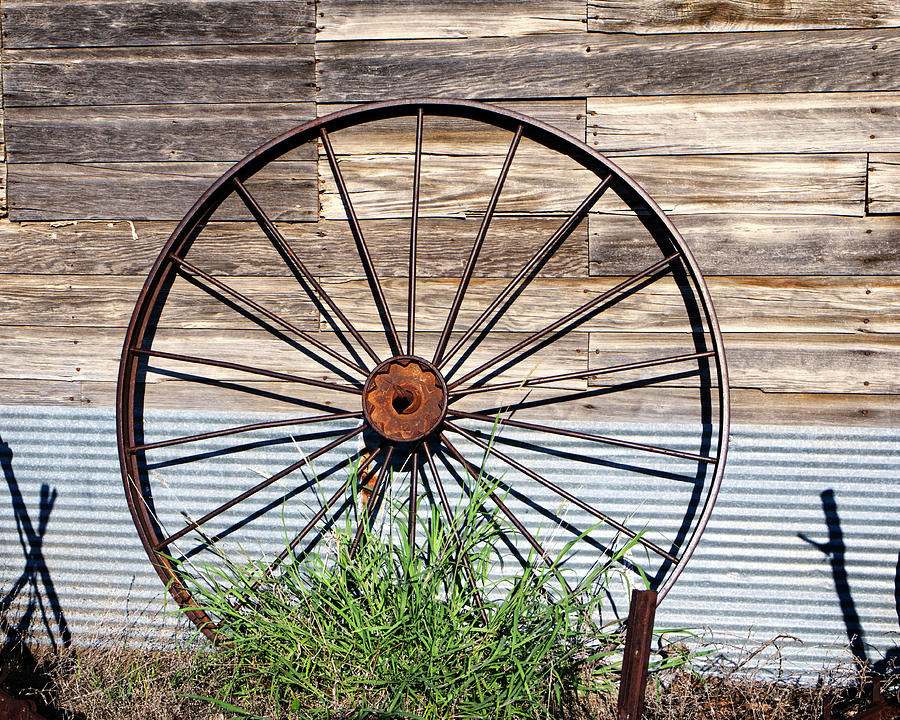 Antique Rusted Metal Wheel Against Weathered Wood Photograph Photograph by Ann Powell
