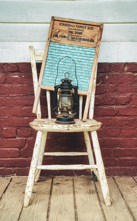 Antique Washboard And Lantern On Weathered Wooden Chair Photograph