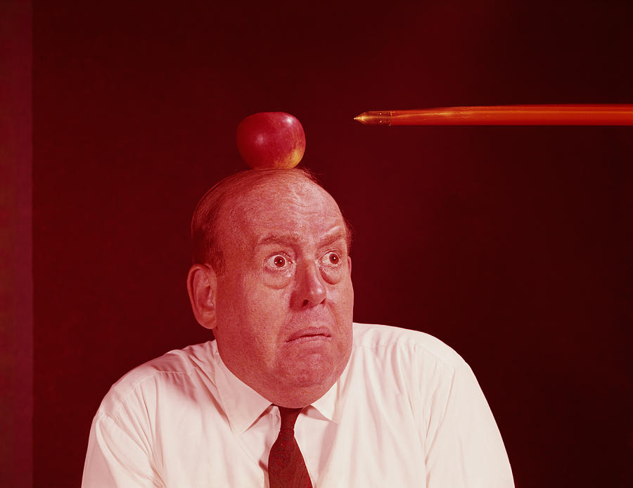 Anxious man looking at arrow directed at apple on top of his head. (Photo by H. Armstrong Roberts/Retrofile/Getty Images) Photograph by H. Armstrong Roberts