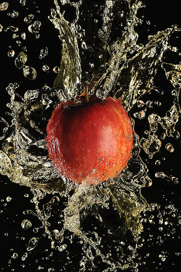 Apple splash by apple juice, close-up. Photograph by Yagi Studio