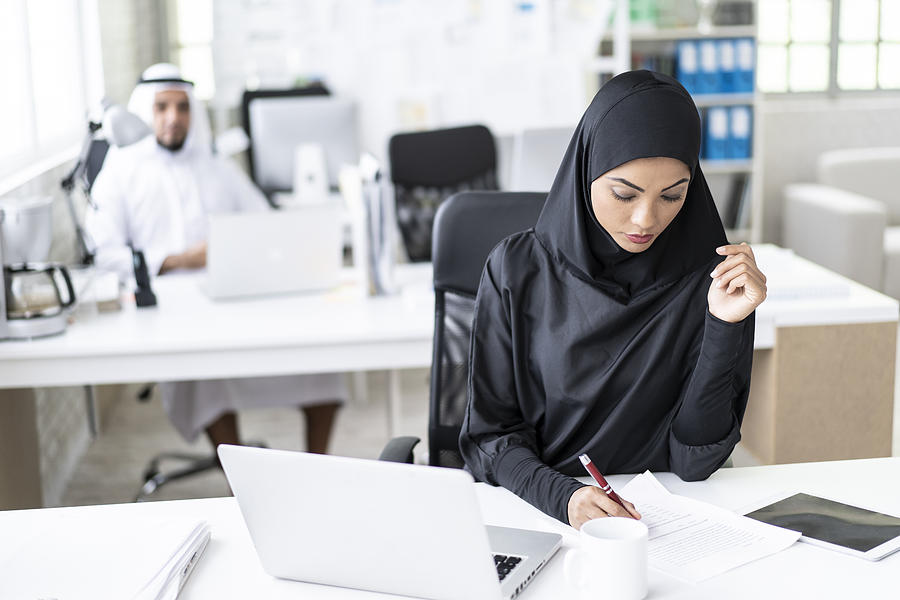 Arab businesswoman working in modern office, writing Photograph by Vladimir Vladimirov