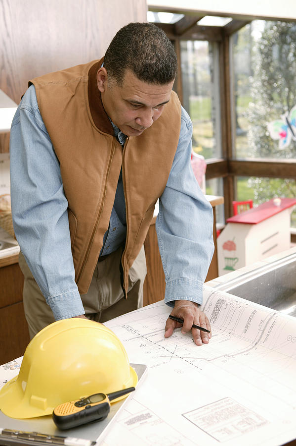 Architect looking at blueprints Photograph by Comstock Images