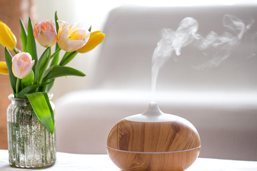 Aroma oil diffuser lamp on the table . Photograph by Puhimec