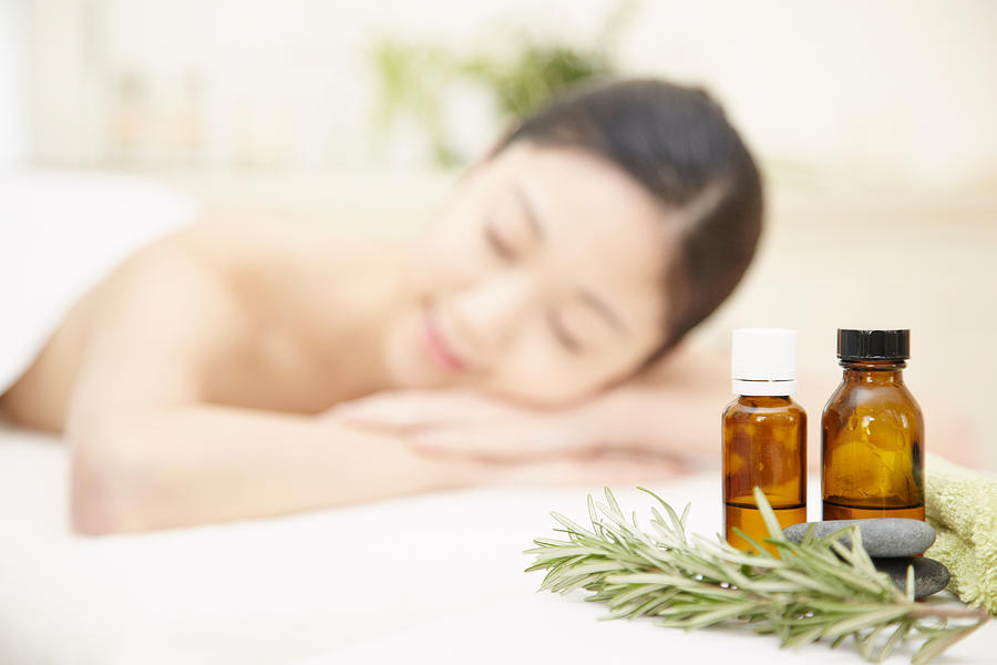 Aromatherapy oils with woman in background Photograph by Hitomi Soeda