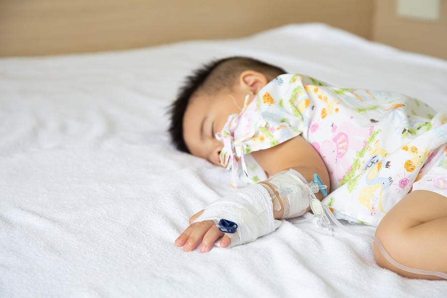 Asian baby boy sleeping on bed with infusion set at child department in the hospital. Children with infectious diseases IPD, Invasive Pneumococcal Disease concept. Infant model one year six months Photograph by Comzeal