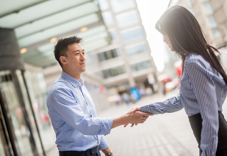 Asian business people handshaking Photograph by Andresr