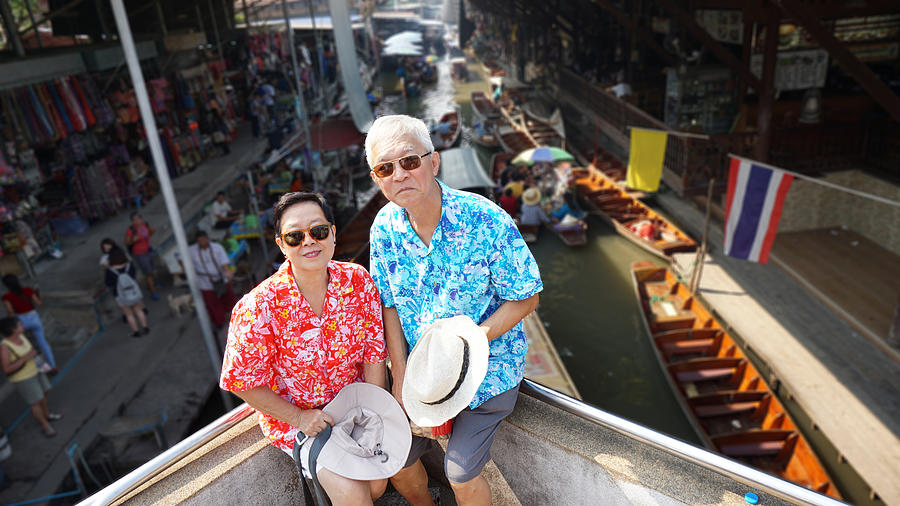 Asian elderly couple having retirement trip to Thailand floating Photograph by Glowonconcept