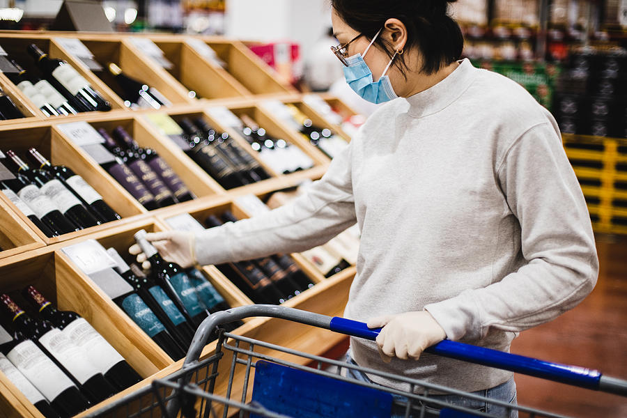 Asian female buying some wine at a supermarket Photograph by Kilito Chan