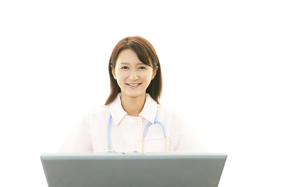 Asian female nurse with laptop computer Photograph by Sunabesyou