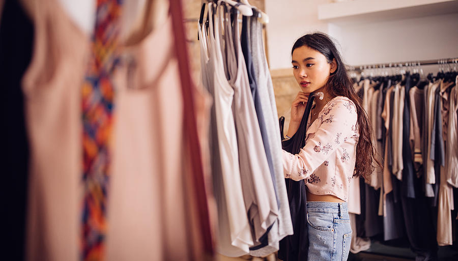Asian hipster woman shopping for clothes inside a clothing store Photograph by Wundervisuals