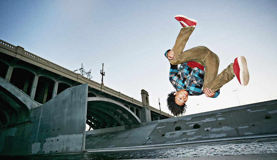 Asian man break dancing under overpass Photograph by Peathegee Inc