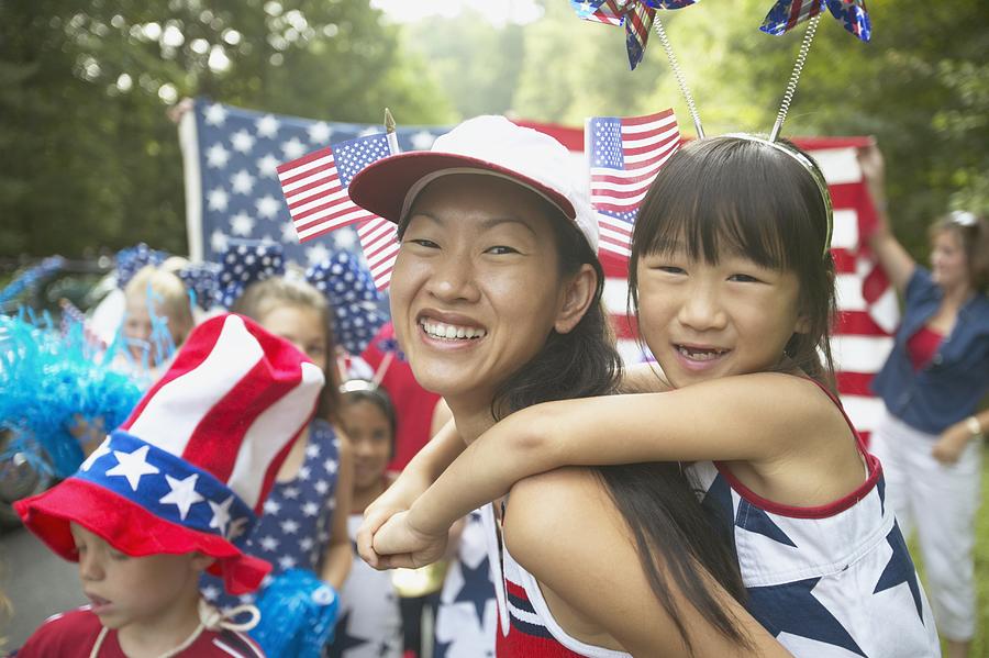 Asian mother and daughter in Fourth of July parade Photograph by Ariel Skelley
