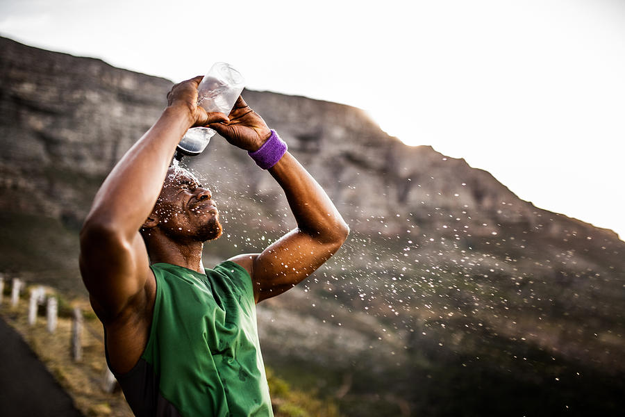 Athlete splashing himself with water from his water bottle Photograph by Wundervisuals