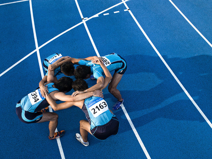 Athletes making a circle Photograph by Michael H