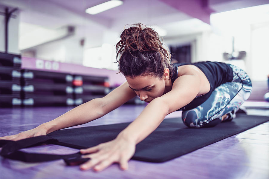 Athletic Female Stretching On Exercise Mat In Gym Photograph by AleksandarGeorgiev
