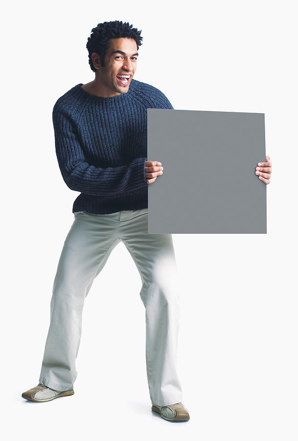Attractive African American Man Wears Khaki Pants Grey Sweater Holds Blank Sign Smiles Enthusiasm Photograph by Photodisc Attractive African American Man Wears Khaki Pants Grey Sweater Holds Blank Sign Smiles Enthusiasm Photograph by Photodisc