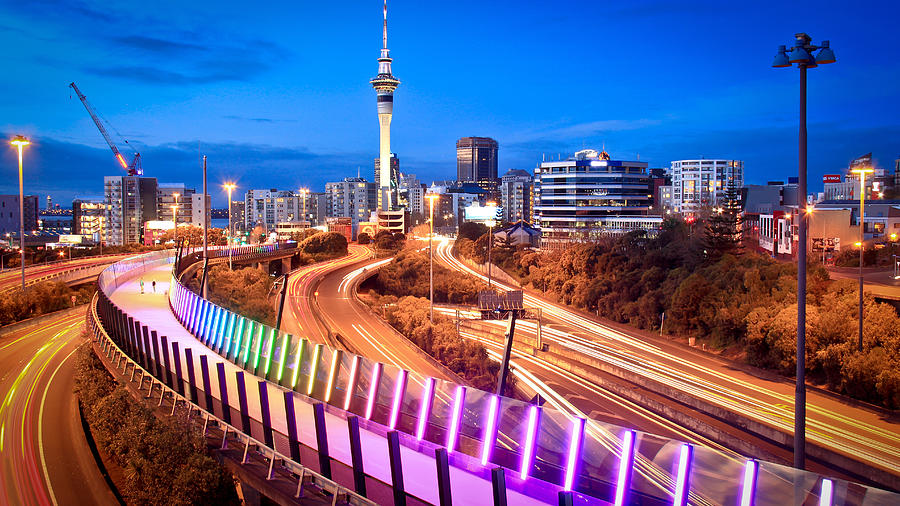 Auckland Lightpath elevated walkaway and urban skyline at dusk with Skytower in middle during evening peak hour Photograph by Kanwal Sandhu