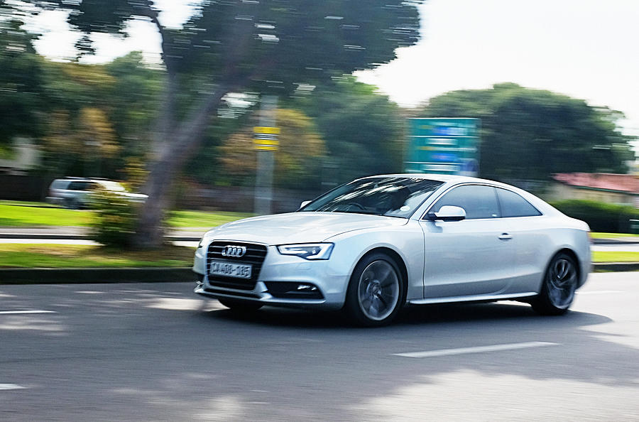 Audi A4 travelling on suburban main road. Photograph by RapidEye