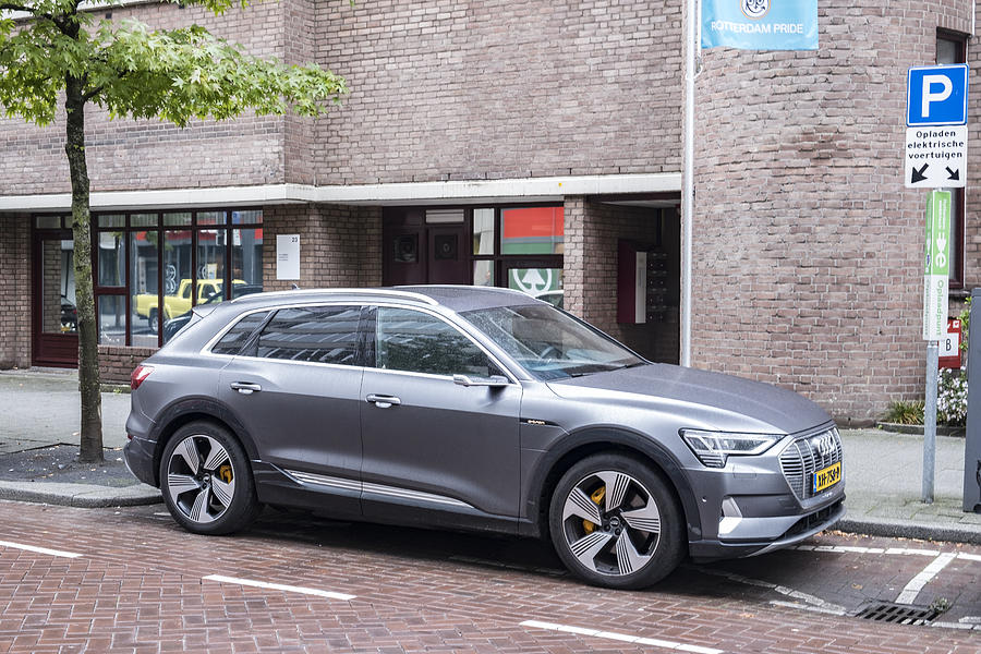 Audi e-tron 55 quattro electric SUV at an electric vehicle charging station in the city Photograph by Sjo