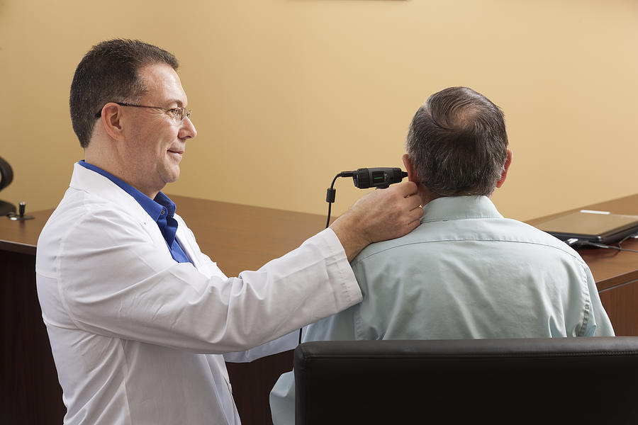 Audiologist doing a video ear canal inspection Photograph by Huntstock