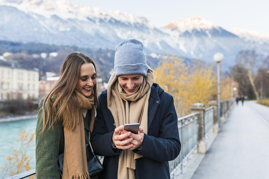 Austria, Innsbruck, happy young couple looking at cell phone Photograph by Westend61