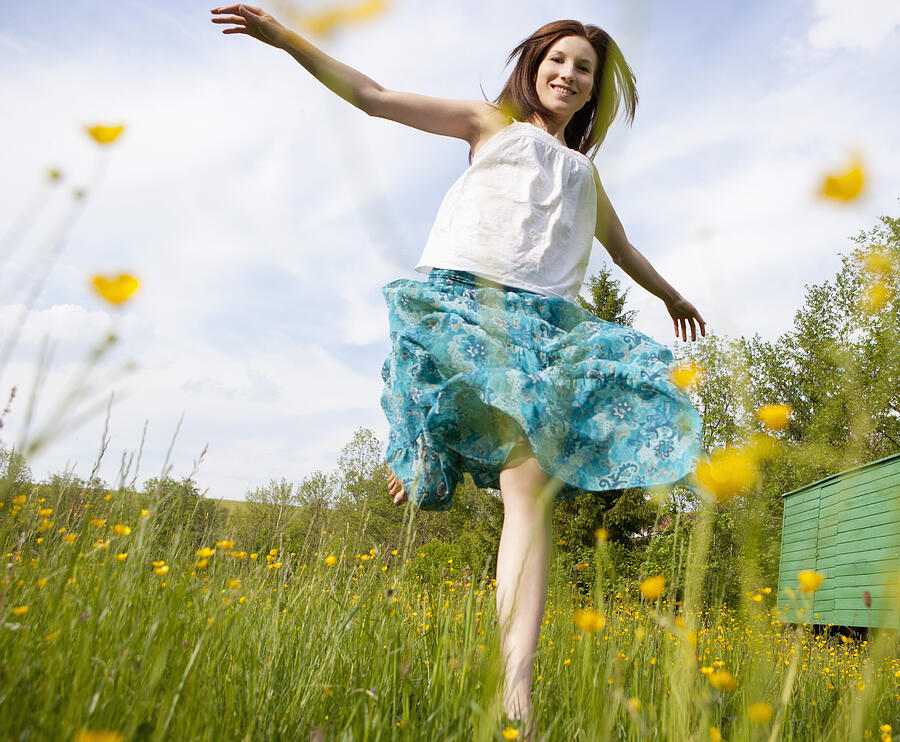 Austria, Young woman running in field of flowers Photograph by Westend61
