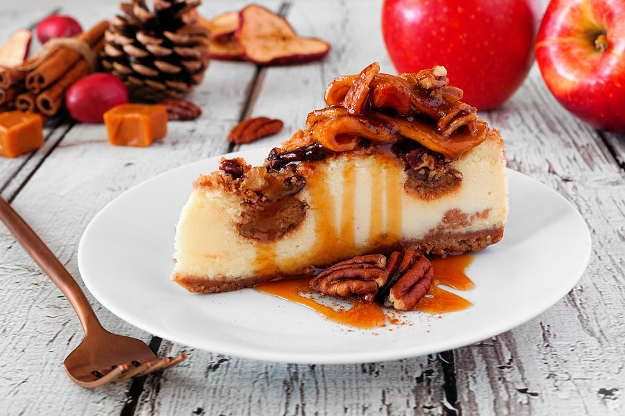 Autumn caramel apple pecan cheesecake, close up side against white wood Photograph by Jenifoto