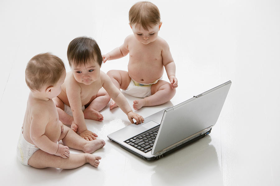 Babies on floor with laptop Photograph by Tom Merton