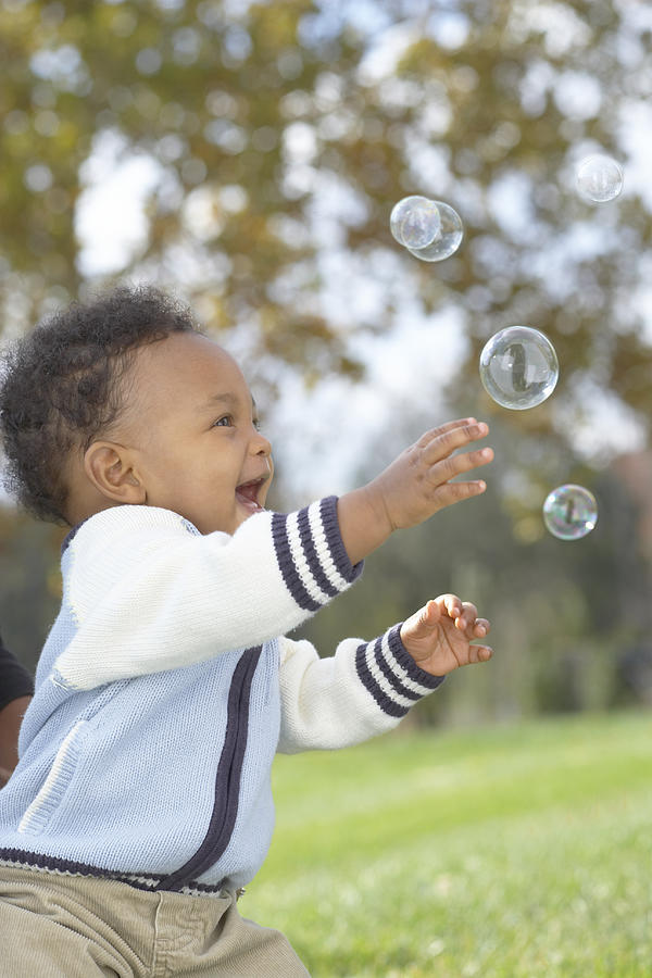 Baby boy (12-17 months) catching bubbles, outdoors Photograph by SW Productions