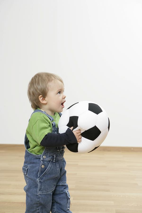 Baby boy holding a football Photograph by Stephan Hoeck
