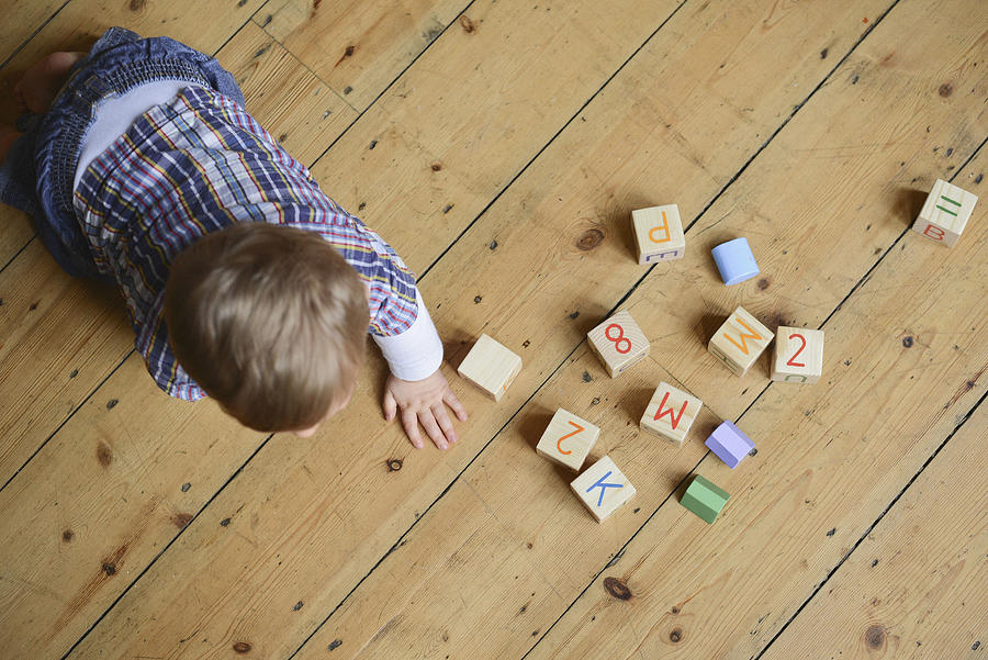 Baby boy playing with abc blocks, overhead view Photograph by PhotoAlto/Neville Mountford-Hoare