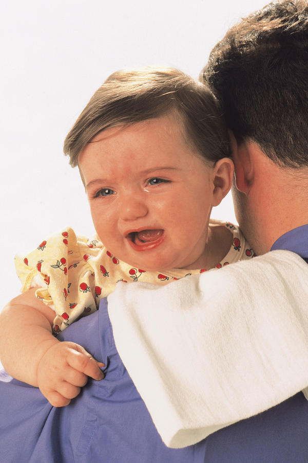 Baby crying over fathers shoulder Photograph by Comstock
