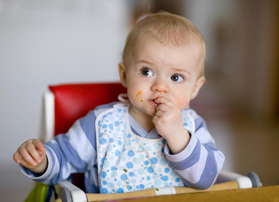 Baby eating Photograph by Johner Images