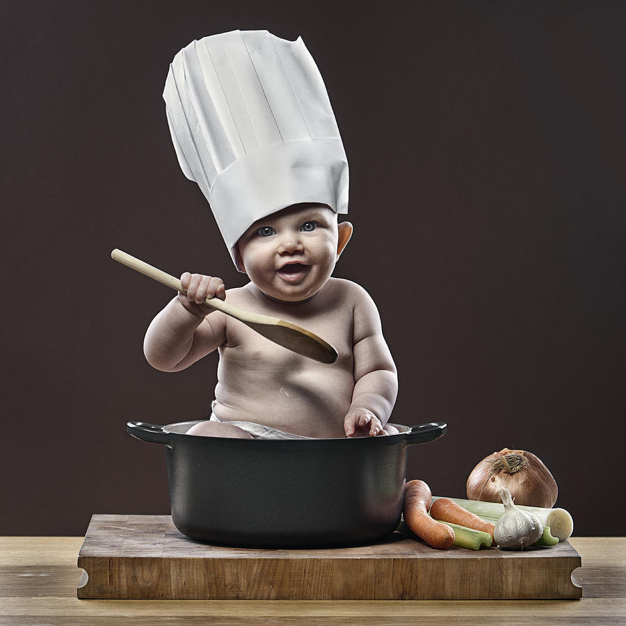 Baby girl (1-6 months) cooking in pot Photograph by Justin Paget