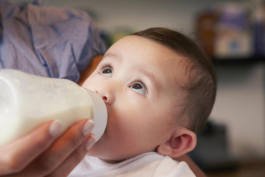 Baby girl drinking bottle of milk Photograph by Emma Kim
