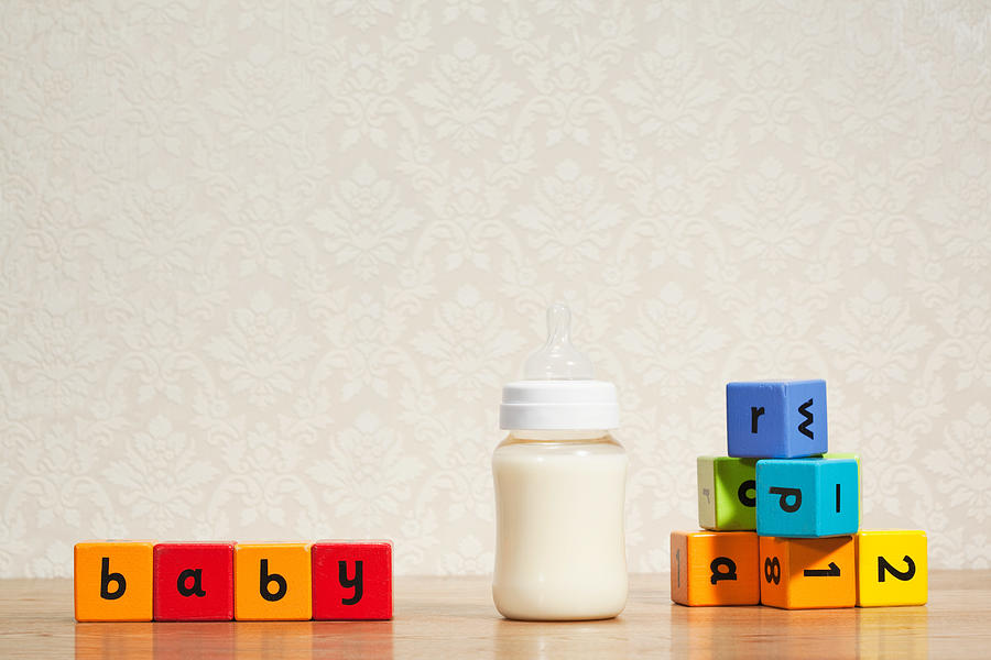 Baby milk and alphabet blocks Photograph by Image Source