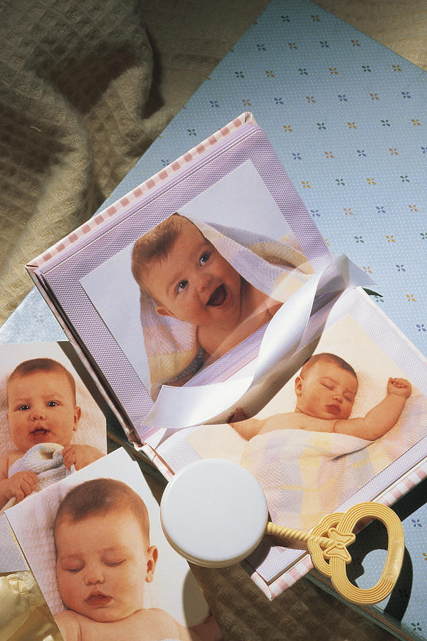 Baby pictures with rattle and blanket Photograph by Comstock