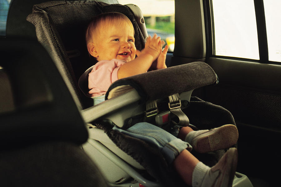Baby sitting in a car seat and clapping hands Photograph by Comstock