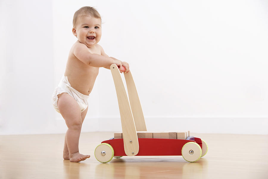 Baby walking with push cart Photograph by Adam Gault